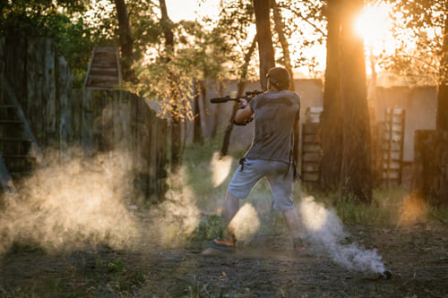 Garçcon jouant au laser game dehors en pleine nature